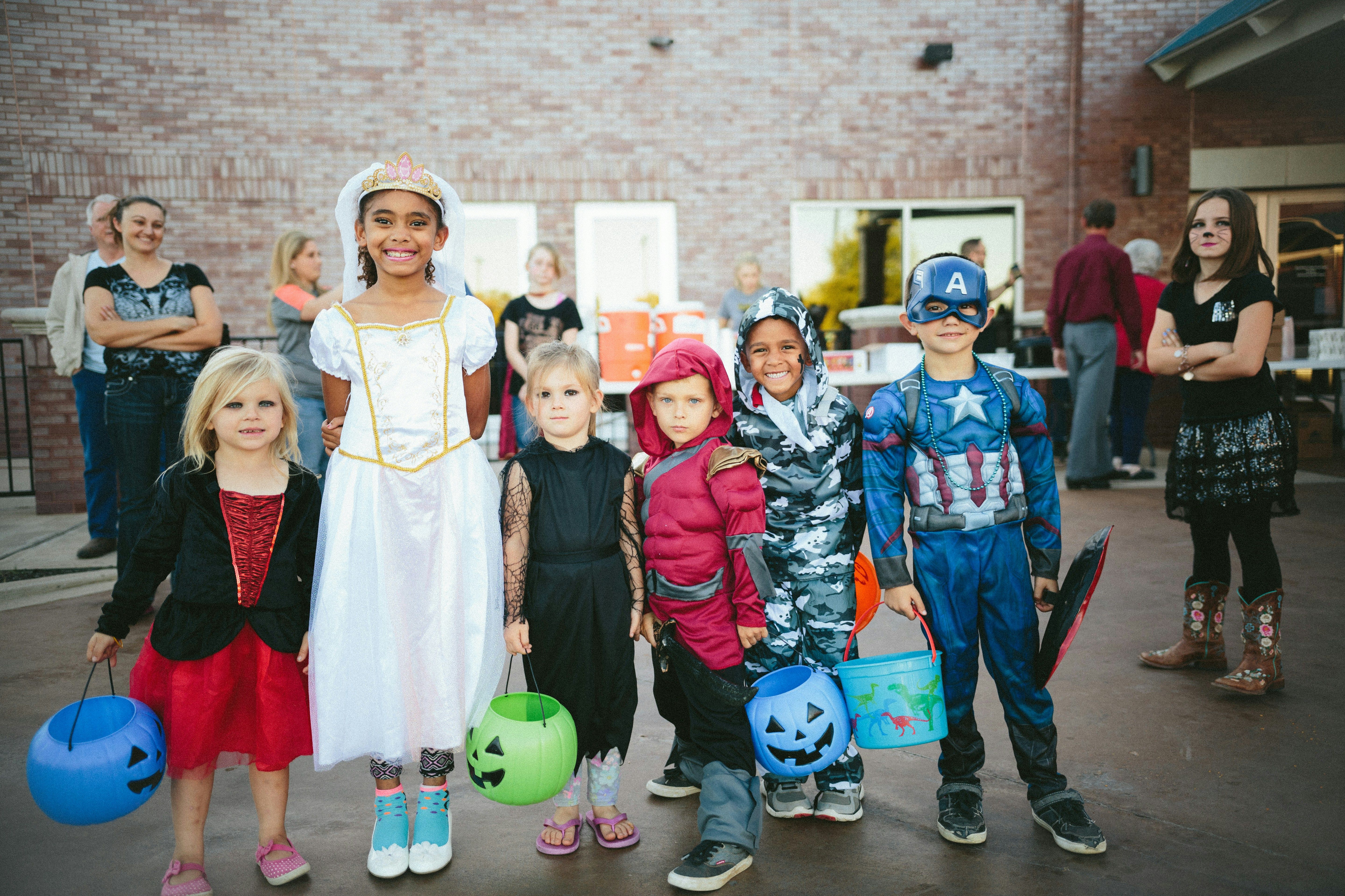 Kids dressed up in halloween costumes outside brick building