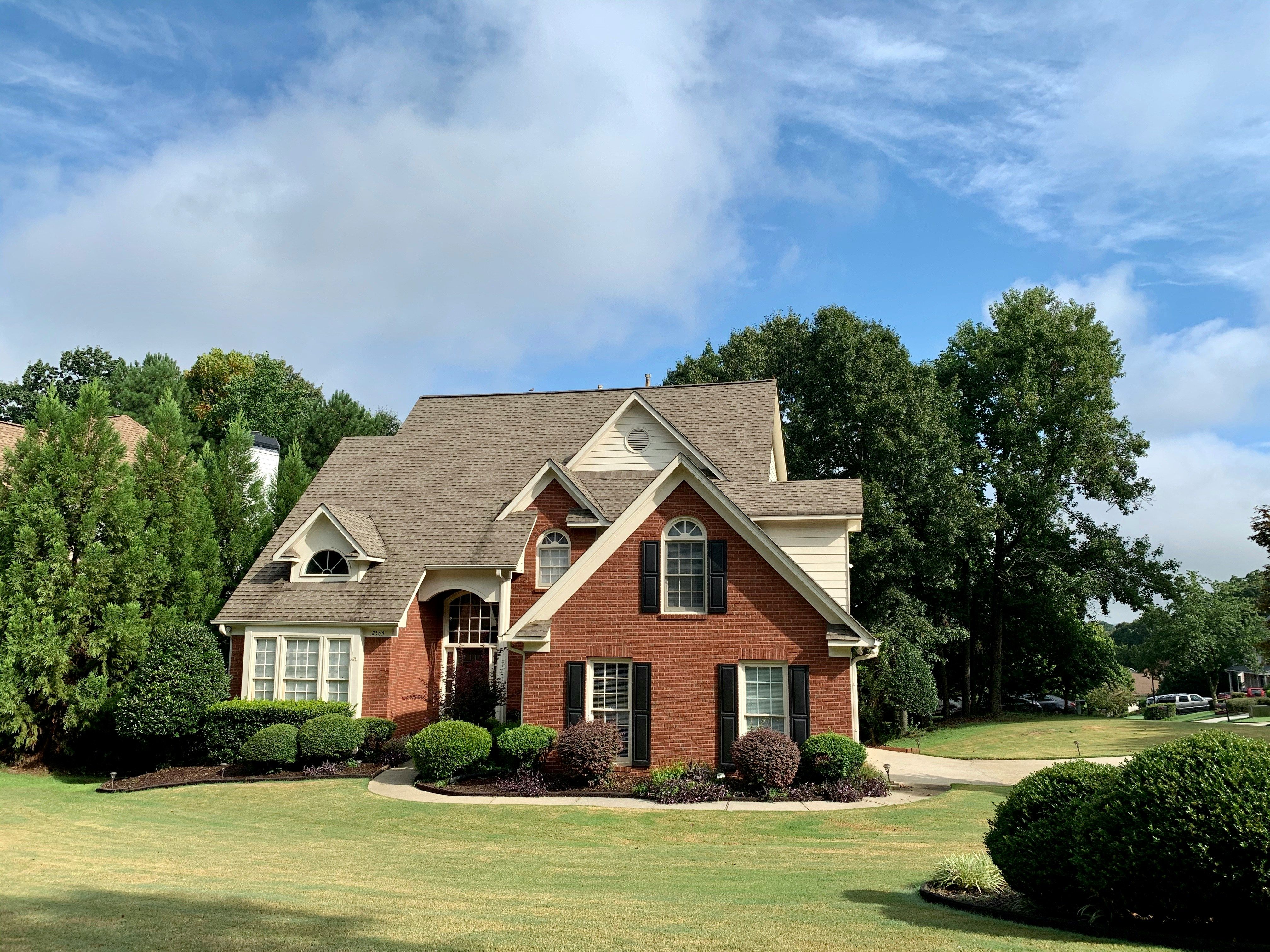 Brick house with blue skies and green grass
